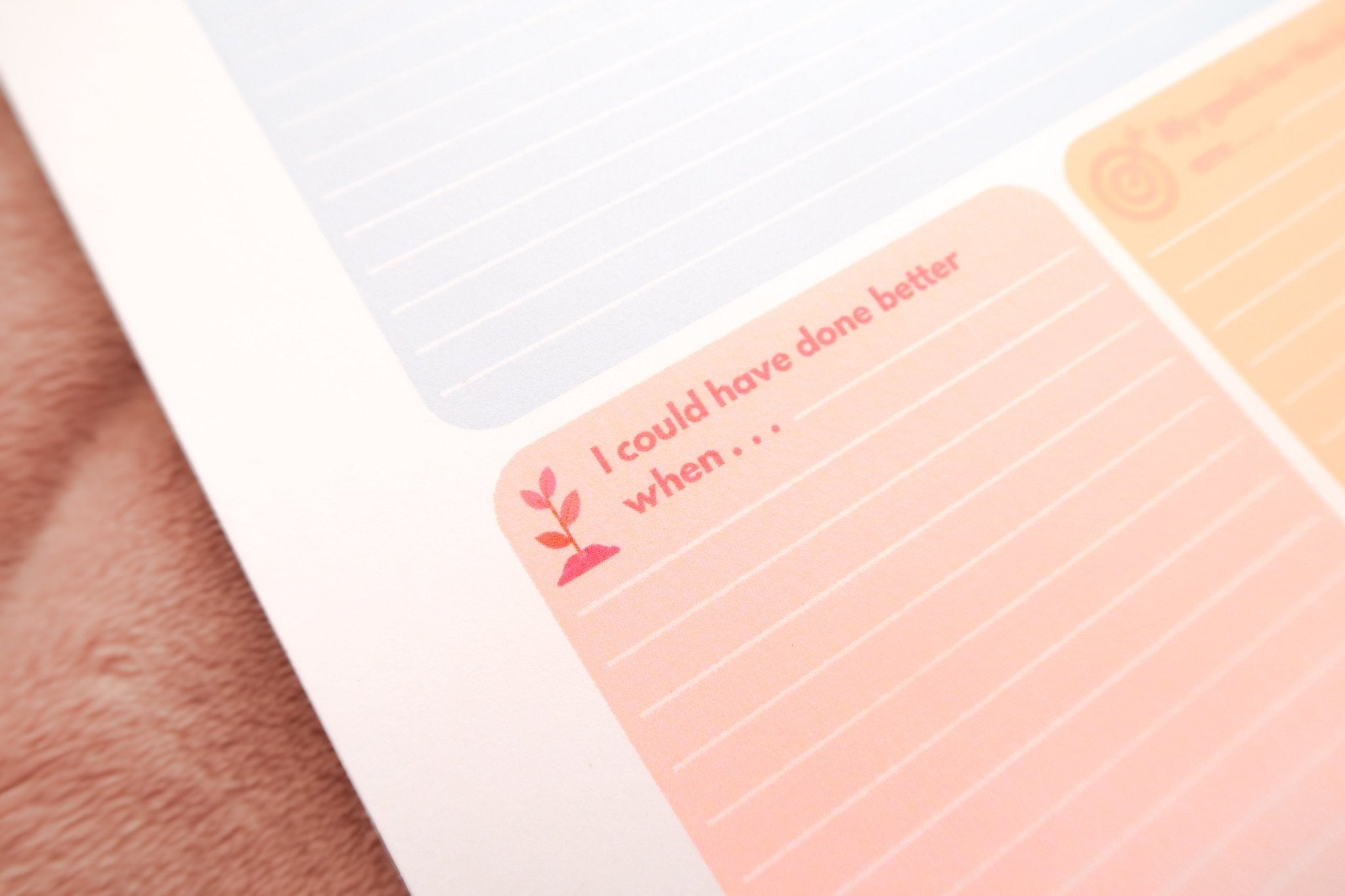 A close up of Totepad's Bubblegum Daily Reflection Notepad on a warm fuzzy pink blanket, showcasing a pink reflection space.