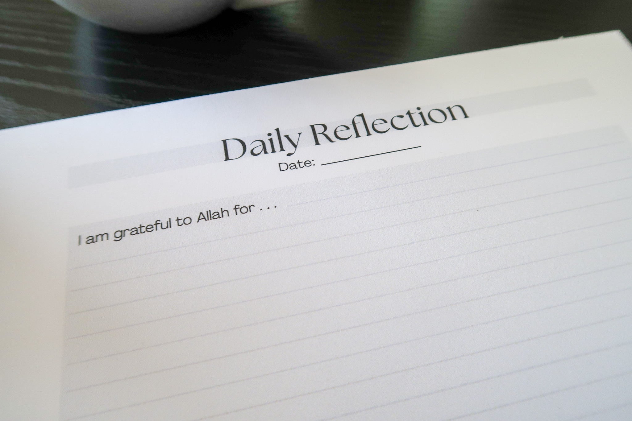 A close up of Totepad's A4 Luxury Daily Reflection Notepad, with the writing prompts visible.