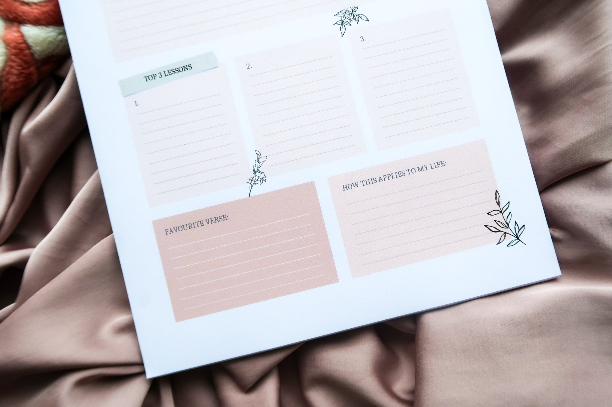 A close up of Totepad's Quran Reflections Notepad on a pastel pink prayer mat.